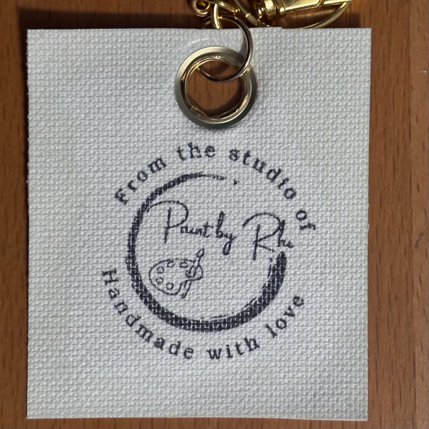 One Layer at a Time keychain, back with studio stamp