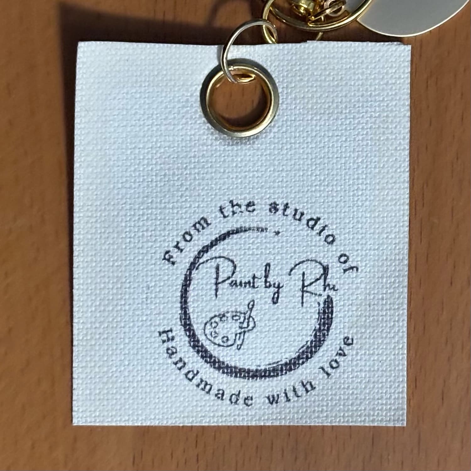 Support Local Artists keychain, back with studio stamp